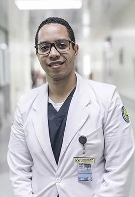 male doctor wearing a white coat and scrubs